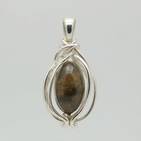 Handmade silver pendant featuring a smooth, polished gemstone set within a delicate wire design, demonstrating jewelry craft