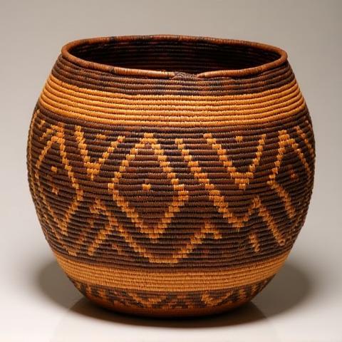 A sturdy, hand-woven basket with a striking geometric pattern created using contrasting natural materials